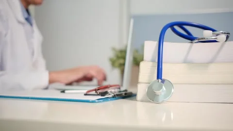 Close up view of stethoscope with books on table and female doctor Stock Footage 251941703