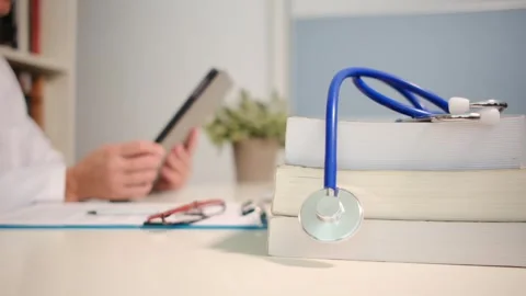 Close up view of stethoscope with books on table and female doctor Stock Footage 251941759