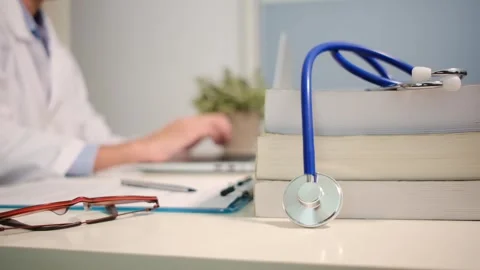 Close up view of stethoscope with books on table and female doctor Stock Footage 251941841