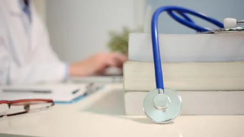 Close up view of stethoscope with books on table and female doctor 스톡 동영상 251941915