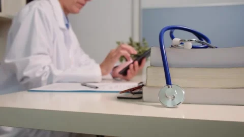 Close up view of stethoscope with books on table and female doctor Stock Footage 251941992