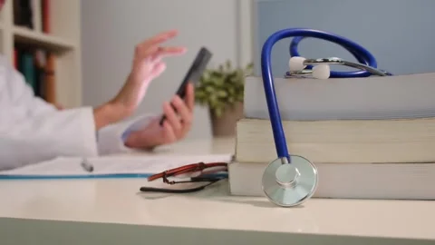 Close up view of stethoscope with books on table and female doctor 스톡 동영상 251942029