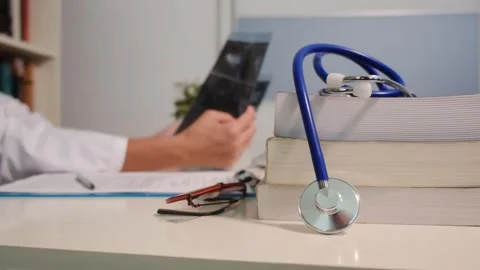 Close up view of stethoscope with books on table and female doctor Stock Footage 251942048