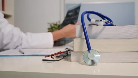Close up view of stethoscope with books on table and female doctor Stock Footage 251942067
