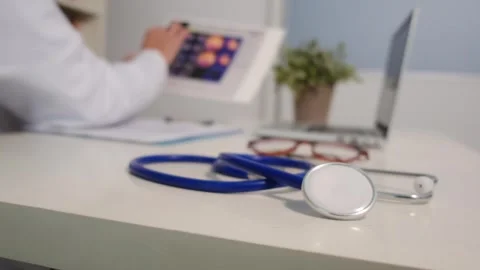 Close up view of stethoscope with books on table and female doctor Stock Footage 251942237