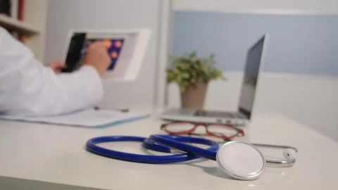 Close up view of stethoscope with books on table and female doctor Stock Footage 251942242