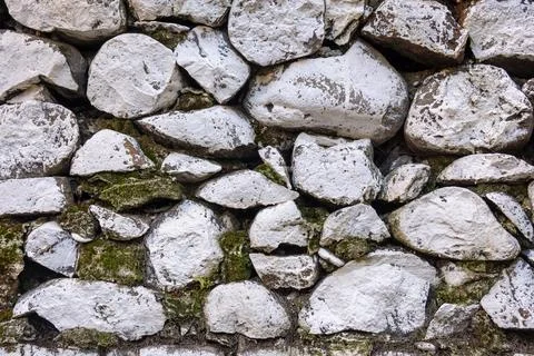 A close-up view of a stone wall composed of irregularly shaped, white stone. Stock Photos