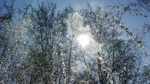 Close-up view of streams of fountain with reflection and lens flare. Water je Stock Photos