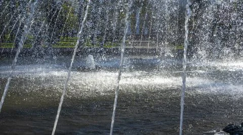 Close-up view of streams of fountain with reflection and lens flare. Water je Stock Photos