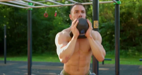 Close-up view of strong man doing Exercises at sports ground. Lifting kettlebell Stock Footage 157890671