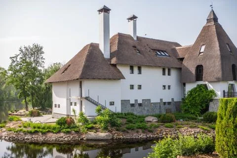 A close view of a structure with an authentic roof with white walls, smokers and Stock Photos