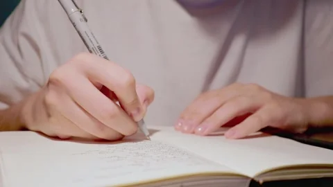 Close up view on student doing homework in white paper notebook in slow motion Stock Footage 163251752