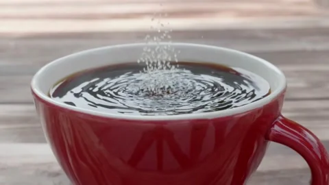 Close-up view of the sugar in the coffee spoon being poured into the espresso re Stock Footage 148751232