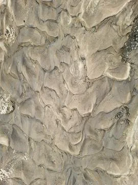 Close up view of sunlit sandy soil patterns showing sediment textures in a .. Stock Photos