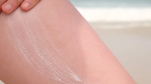 Close up view of sunscreen being applied to bare skin at the beach. The white Stock Footage 313508113