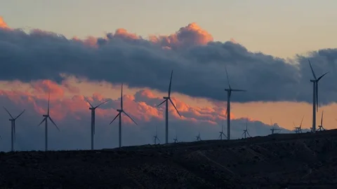 Close Up View of Sunset Clouds Passing Over A Desert Wind Farm Video stock 76851857