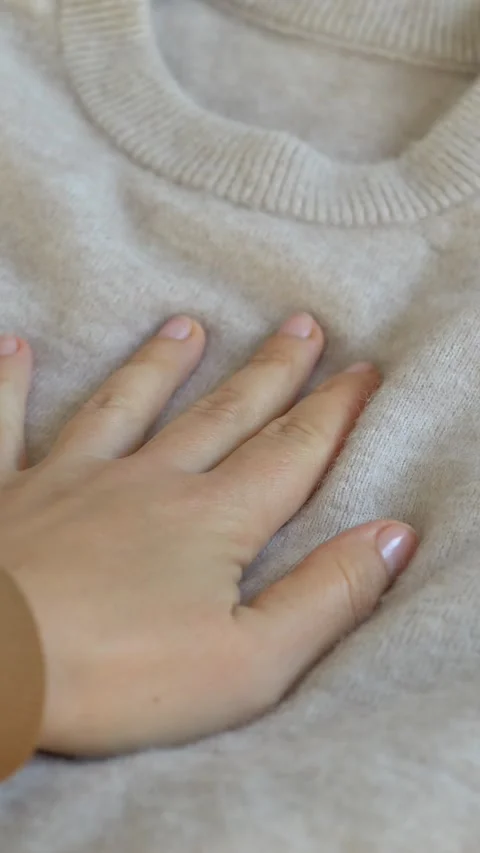 Close view of sweater collar showing knit structure and quality, woman hand Vídeo Stock 332896125