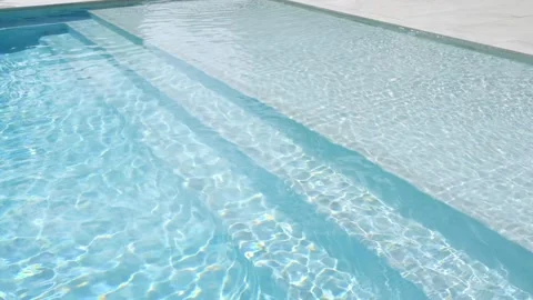 Close up view of swimming pool with clear blue water. Sunlight reflecting sun Видео 275825598