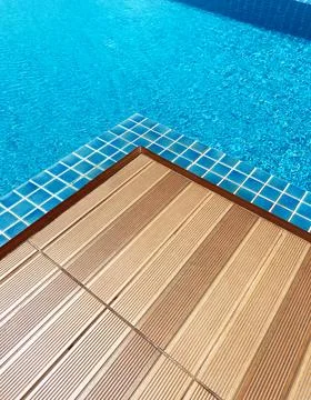Close-up view of a swimming pool corner featuring clear blue water, textured Stock Photos
