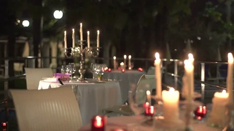 Close-up view of the table sets romantically decorated with lighting candles at Stock Footage 82575147
