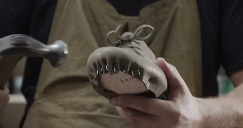 Close up view of tailor nailing and fixing blank for shoes in private leather Stock Footage 200127705