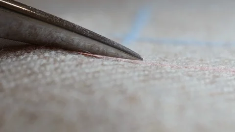 Close up  view of tailors cutting tweed while working on creation of custom-made Video stock 128993531