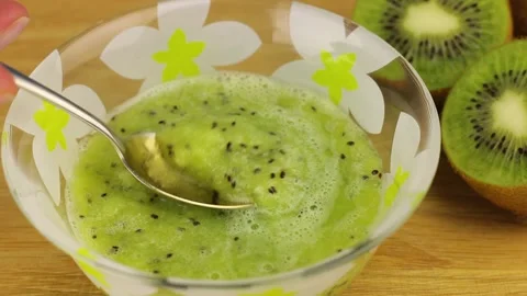 Close-up view of taking a spoonful of kiwi smoothie from a glass bowl. Stockbeeldmateriaal 151039662