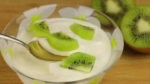 Close-up view of taking a spoonful of yogurt with kiwi fruit. Vidéo 151017774