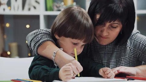 Close up view of teacher helping a little cute adorable little toddler boy with Stock Footage 105599796