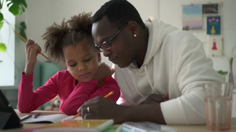 Close-up view of teacher or father helping daughter in study and sitting at Stock Footage 168733197