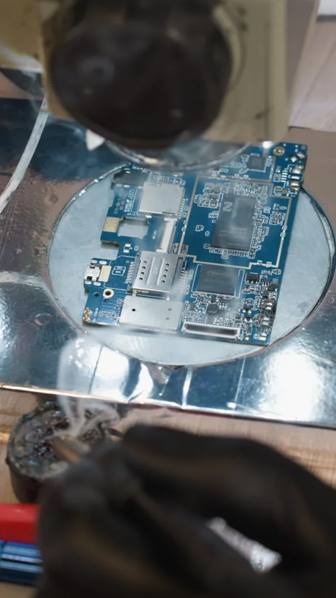 Close-Up View of Technician Soldering Circuit Board on Electronics Workbench Stock Footage 310490604