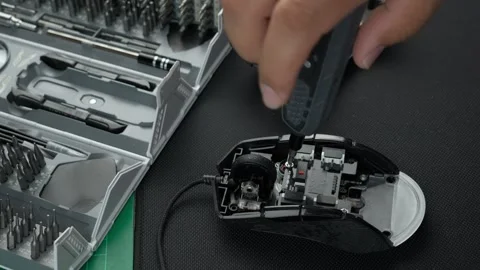 Close up view of a technician tightening a screw on a mouse Stock Footage 275400391