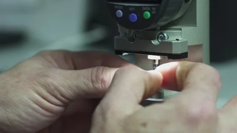 Close-up view of a technician using a precision measuring instrument to inspect Stock Footage 321896728