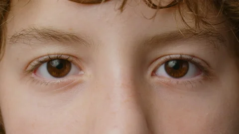 Close-up view of a teenager. The guy opens his eyes in slow motion Stock Footage 229440061