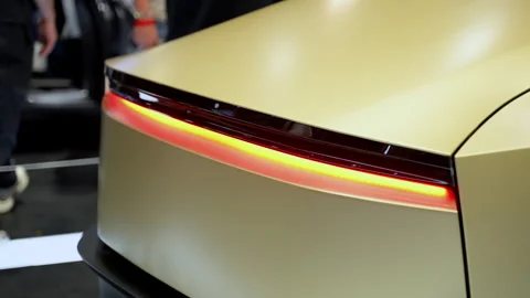 Close up view of Tesla robotaxi concept showcased at an indoor auto show with Stock Footage 330988434