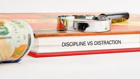 Close up view of a textbook titled Discipline vs Distraction resting on a tab Stock Photos