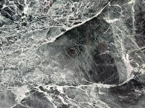 Close-up view of a textured abstract marble surface with dark hues. Stock Photos