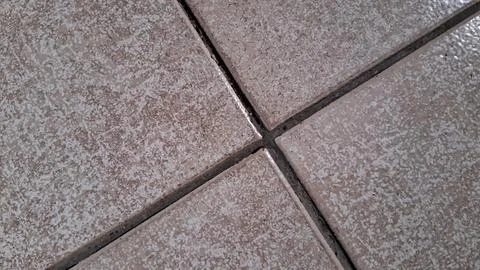 Close up view of textured beige square ceramic floor tiles 스톡 사진