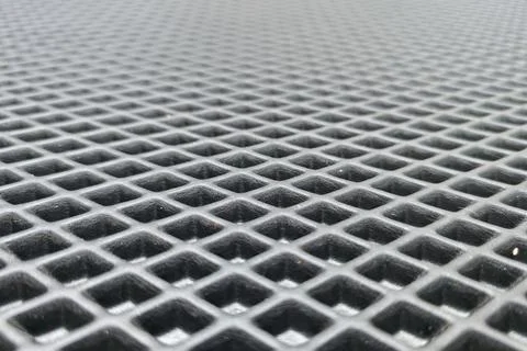 Close-up view of textured black surface featuring a grid pattern and hexagonal Stock Photos
