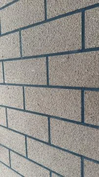 Close-up view of a textured brick wall with dark grout lines, angled perspe.. Stock Photos