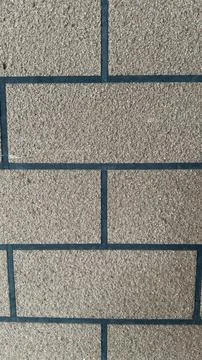 Close-up view of a textured brick wall with dark grout lines, a detailed ar.. Stock Photos