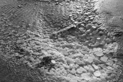 Close-up view of textured icy surface with scattered snow patterns Stock Photos