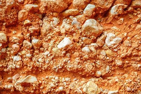 Close-up View of a Textured Orange Clay Wall With Pebbles and Natural Featu.. 스톡 사진