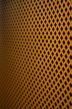 A Close-Up View of a Textured Orange Grate with a Unique Diamond Pattern Sh.. Stock Photos
