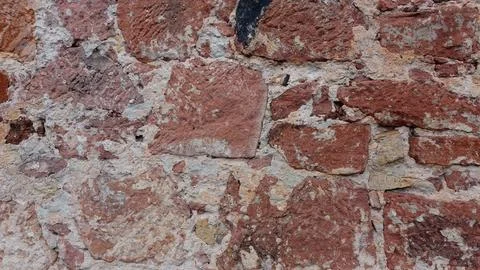 Close-up View of Textured Red Stone Wall With Natural Variations in Color Foto stock