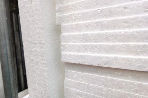 Close-up view of textured white polystyrene sheets stacked against a wall in a Stock Photos