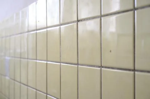 Close-up view of textured yellow ceramic tiles on a wall surface Stock Photos