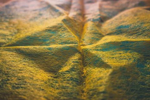 Close up view of thin orange fabric over blue backdrop imitating surface topo Stock Photos