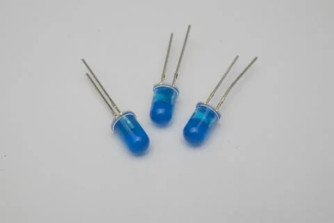 Close-up view of three blue LED (Light Emitting Diode) components on a gray Stock Photos