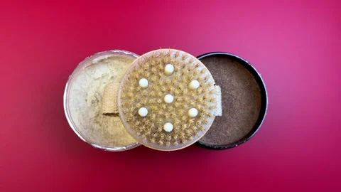 Close-up view of three cosmetic containers with textured lids, showcasing Stock Footage 321740014